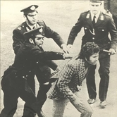 Αστυνομικοί συλλαμβάνουν διαδηλωτή.